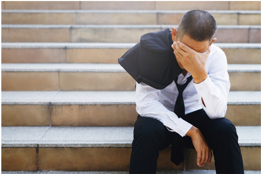 stressed lawyer sitting on steps. anxiety depression poor mental health