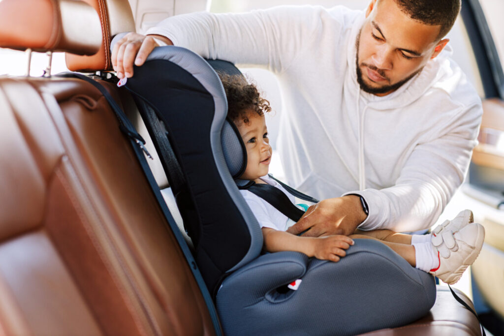 child in car seat safety parent buckling child