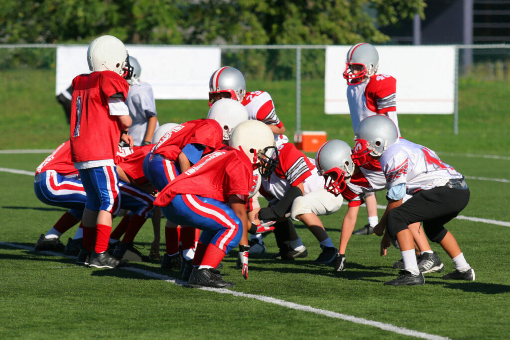 group of kids wearing helmets to play football